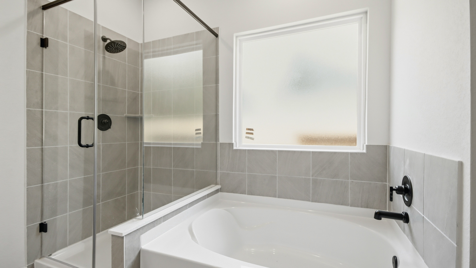 Primary bathroom with soaker tub and tile shower with semi frameless glass in New Waverly TX