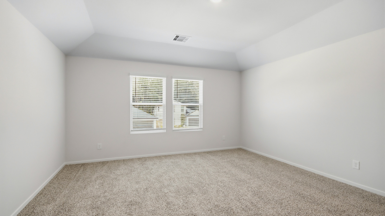 Second story game room with carpet flooring with bright windows in this multi functional space in New Waverly TX