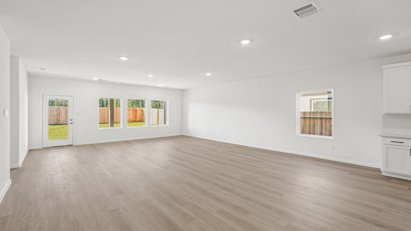 Spacious living area with vinyl flooring