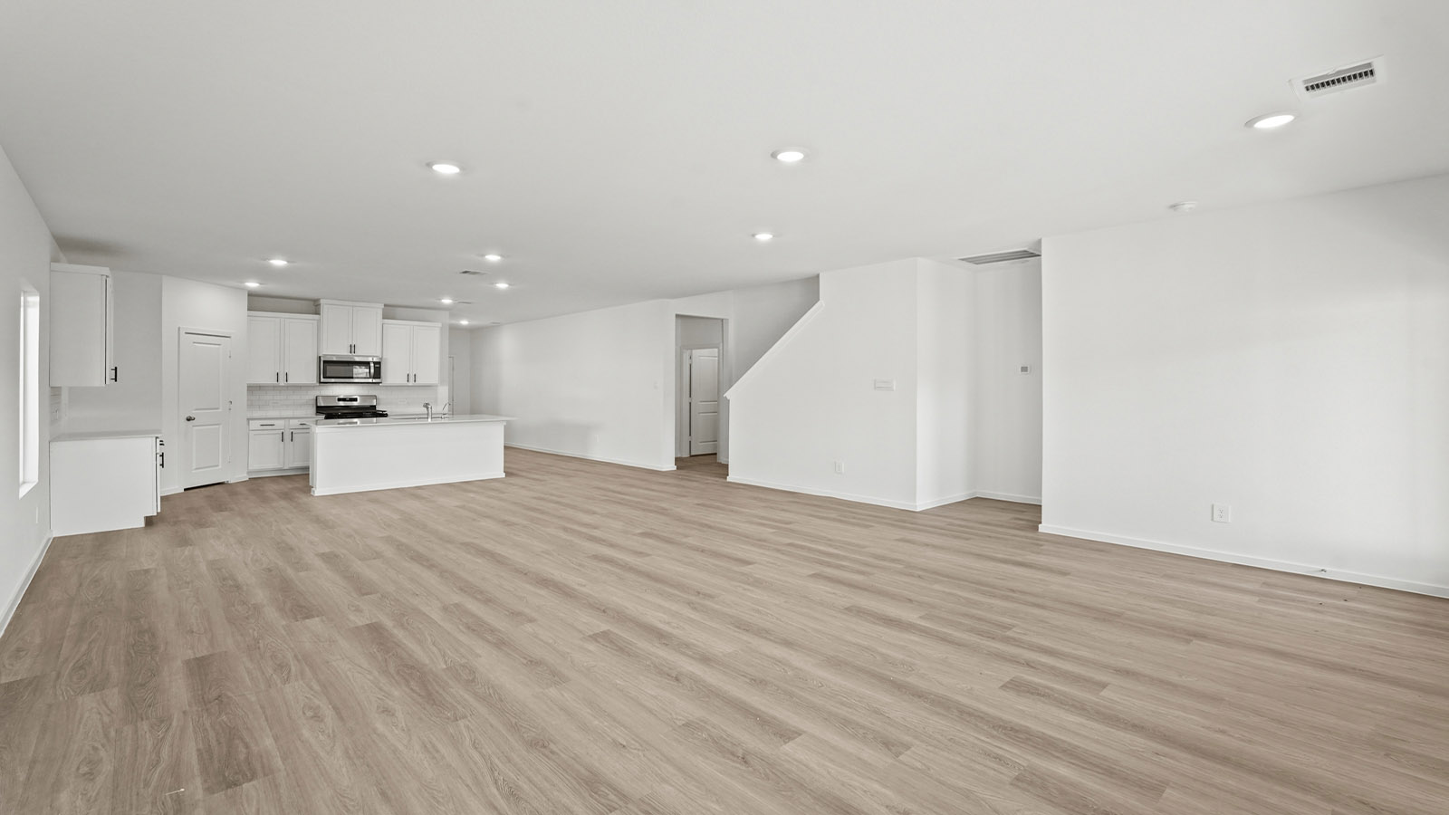 Spacious living area with vinyl flooring