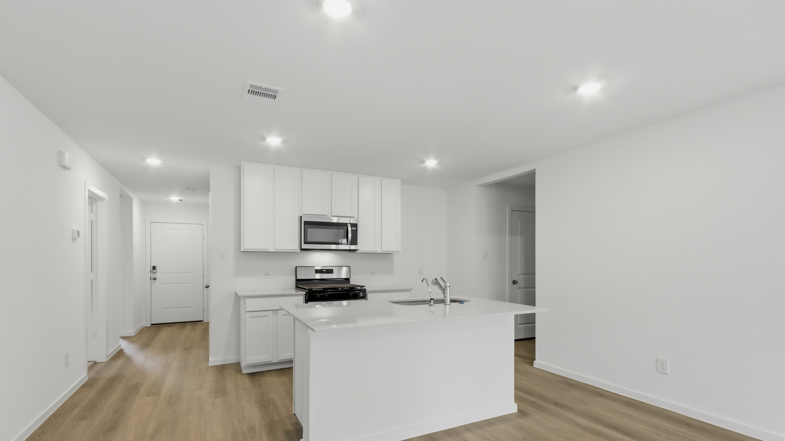 Kitchen with quartz countertops and an island and vinyl floor