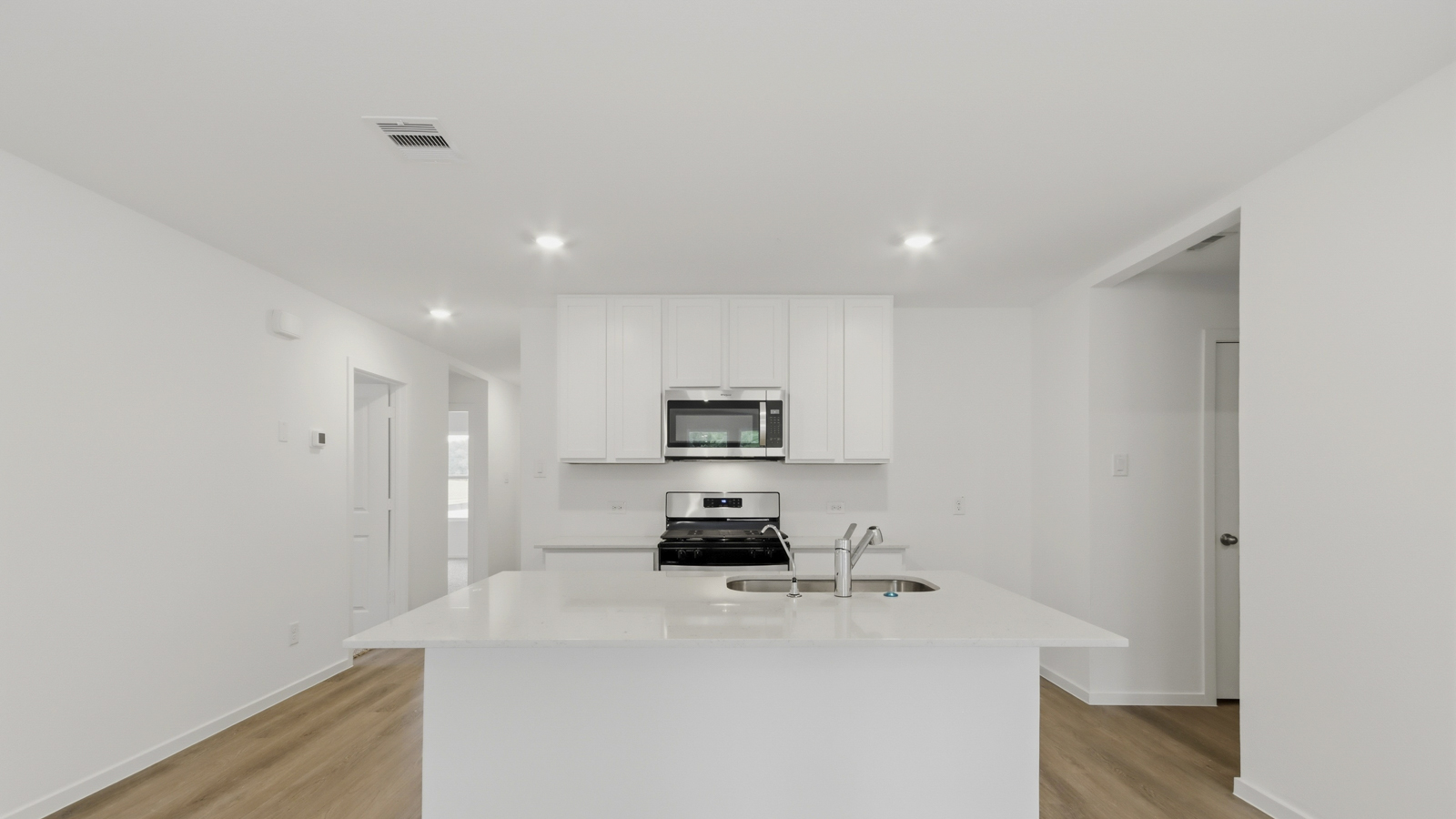 Kitchen with quartz countertops and an island and vinyl floor