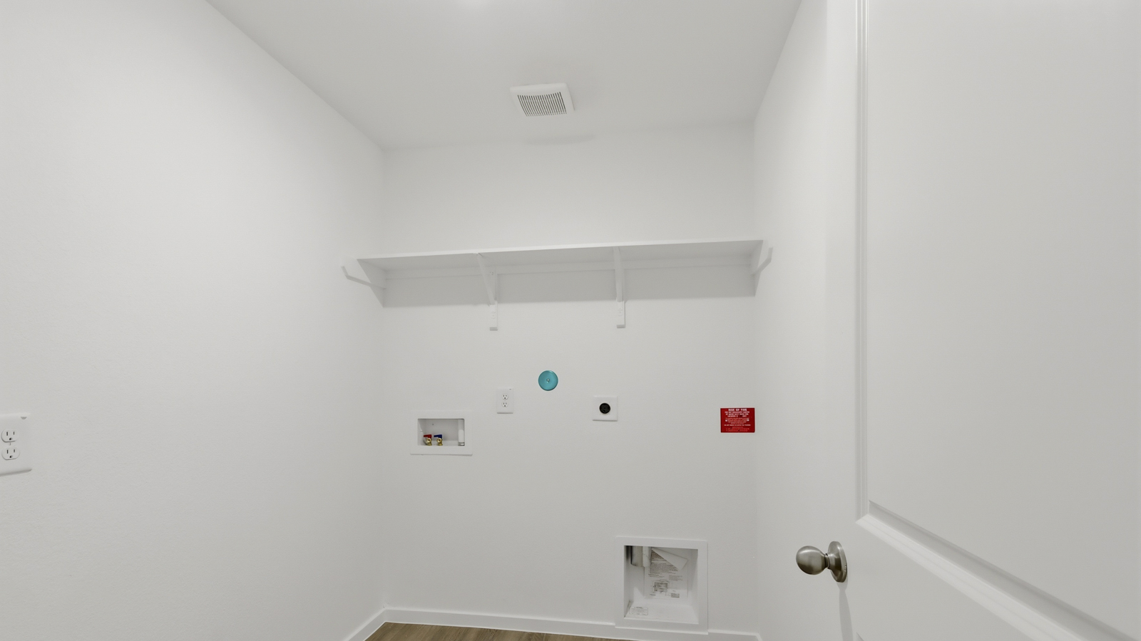 Utility room with storage located off the entry hallway and garage door