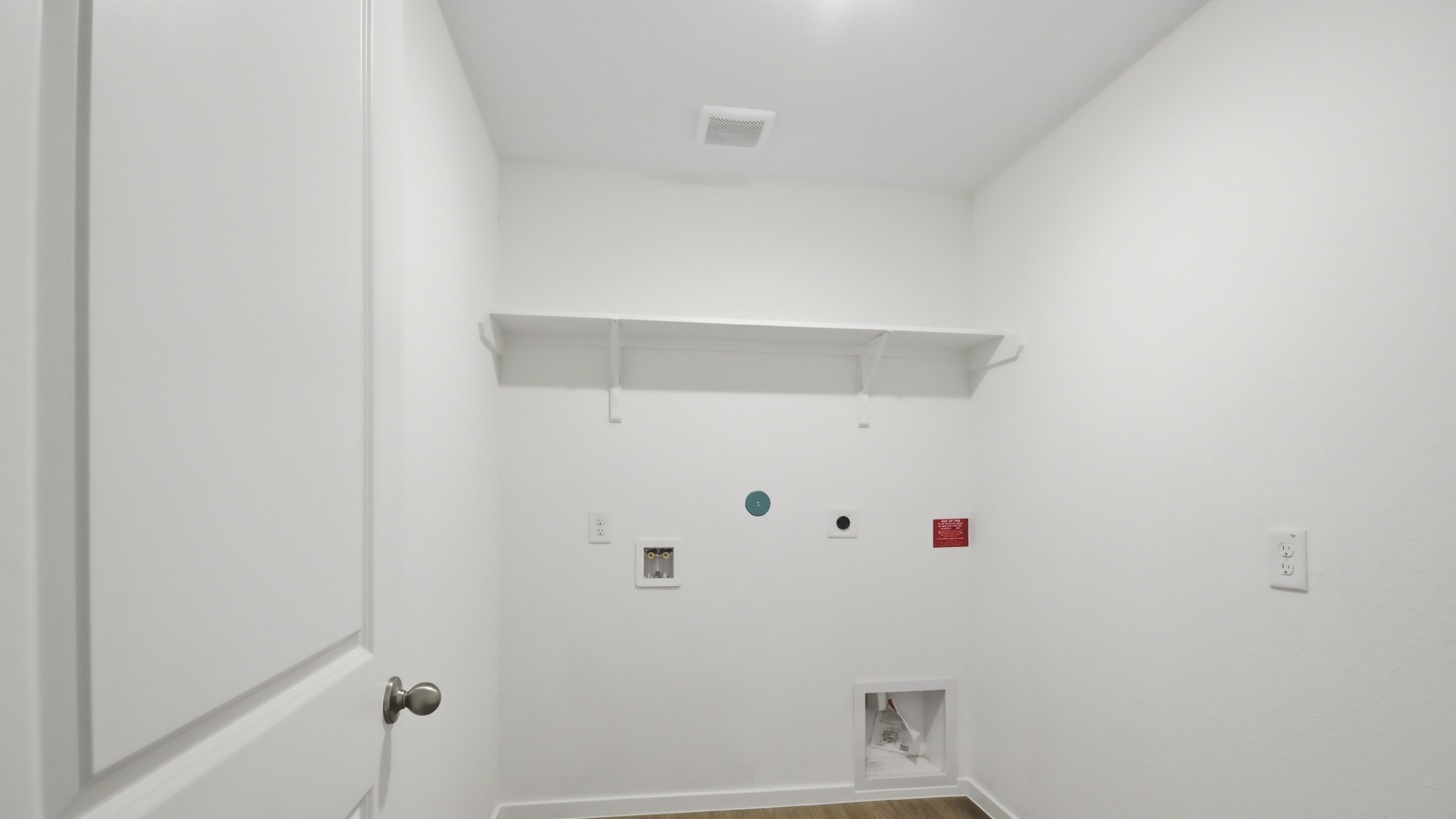 Utility room with storage located off the entry hallway and garage door