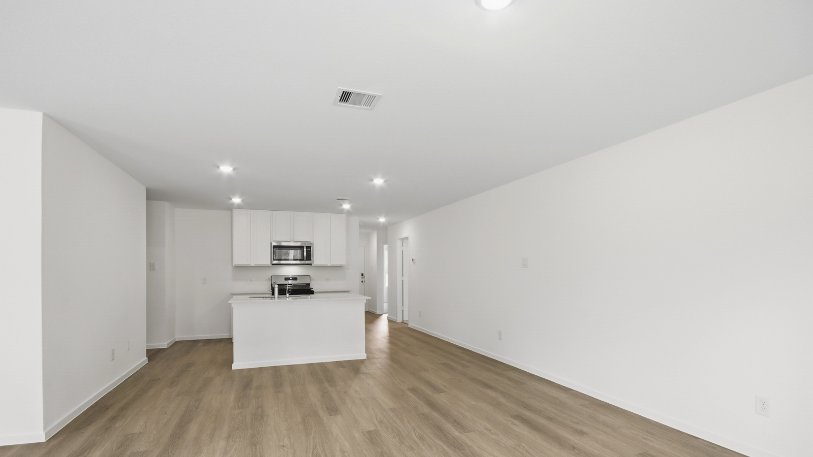 Kitchen with stainless steel appliances, quartz countertops and modern hardware and an island and vinyl floor