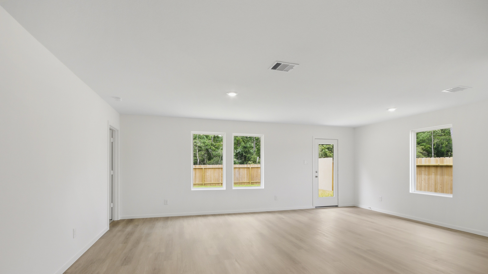 Spacious living area with vinyl flooring and bright windows in New Waverly TX