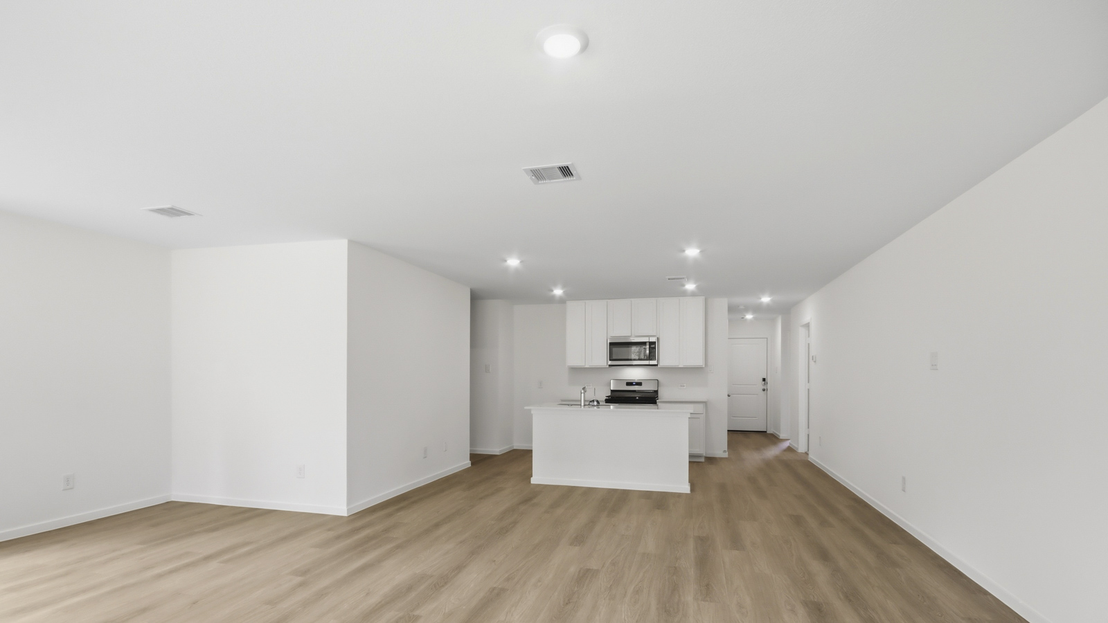 Kitchen with stainless steel appliances, quartz countertops and modern hardware and an island and vinyl floor