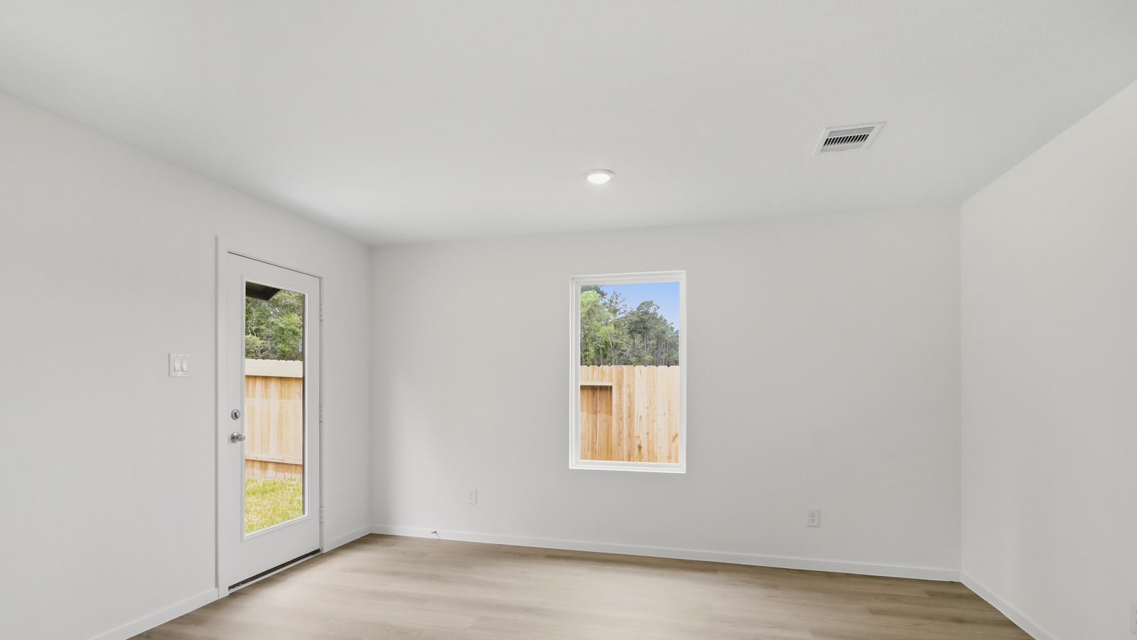 Spacious living area with vinyl flooring and bright windows in New Waverly TX
