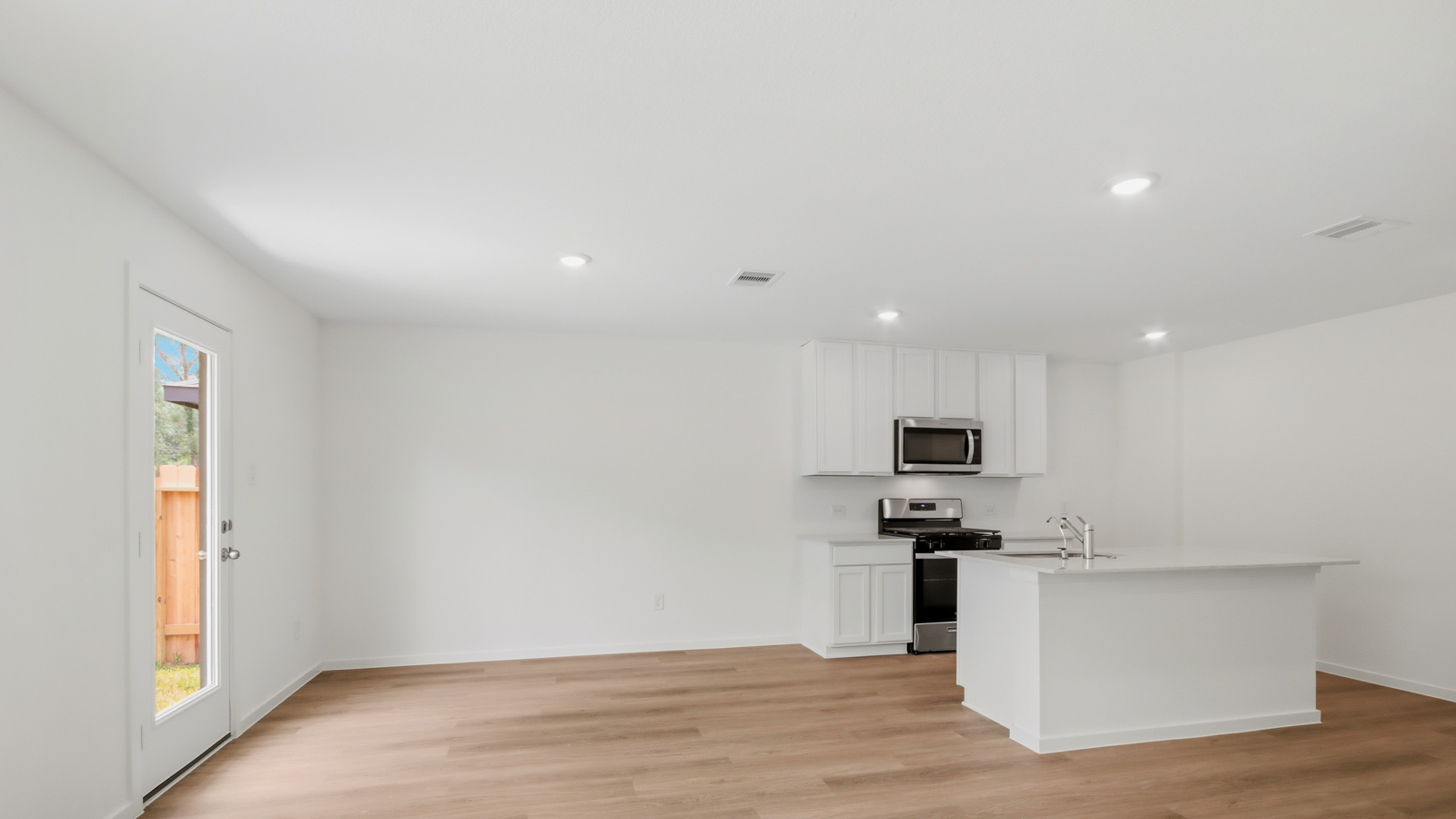 Kitchen with stainless steel appliances, quartz countertops and modern hardware and an island and vinyl floor