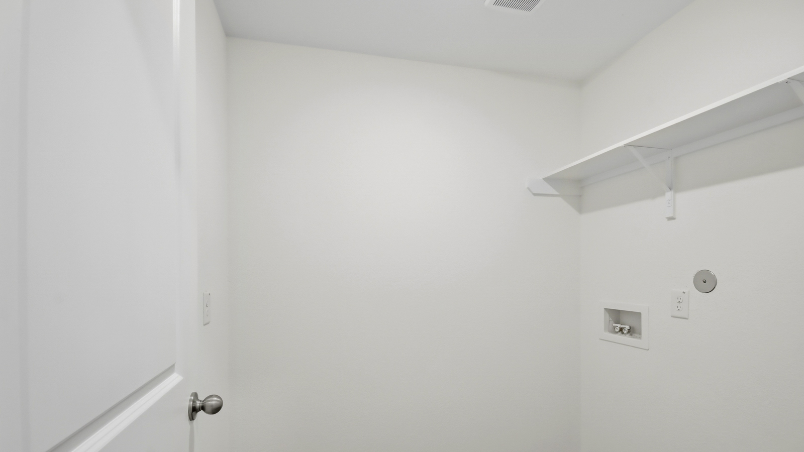 Utility room with storage located off the entry hallway and garage door