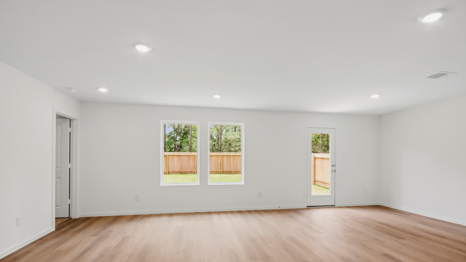 Spacious living area with vinyl flooring and bright windows in New Waverly TX
