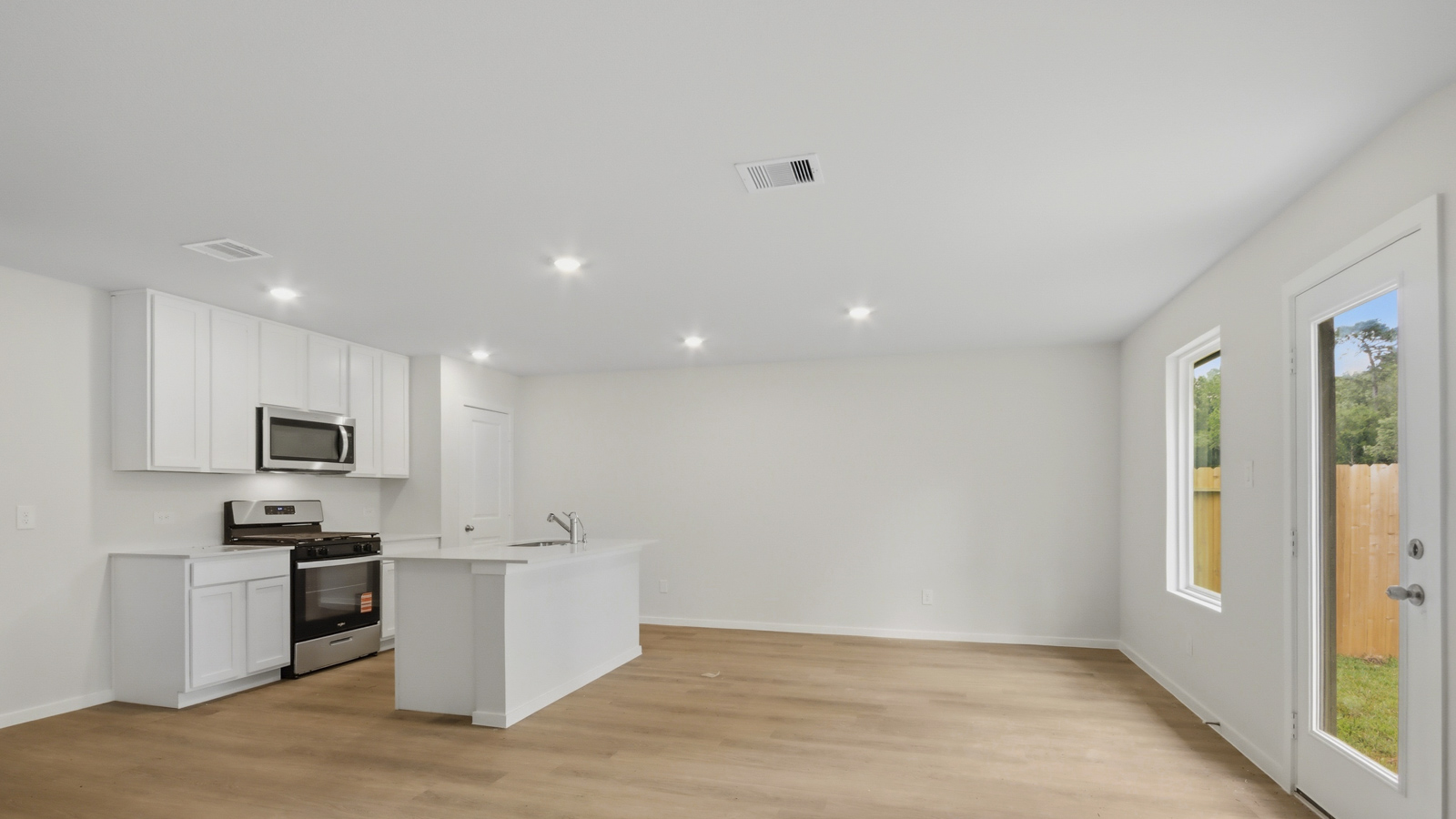 Kitchen with stainless steel appliances, quartz countertops and modern hardware and an island and vinyl floor
