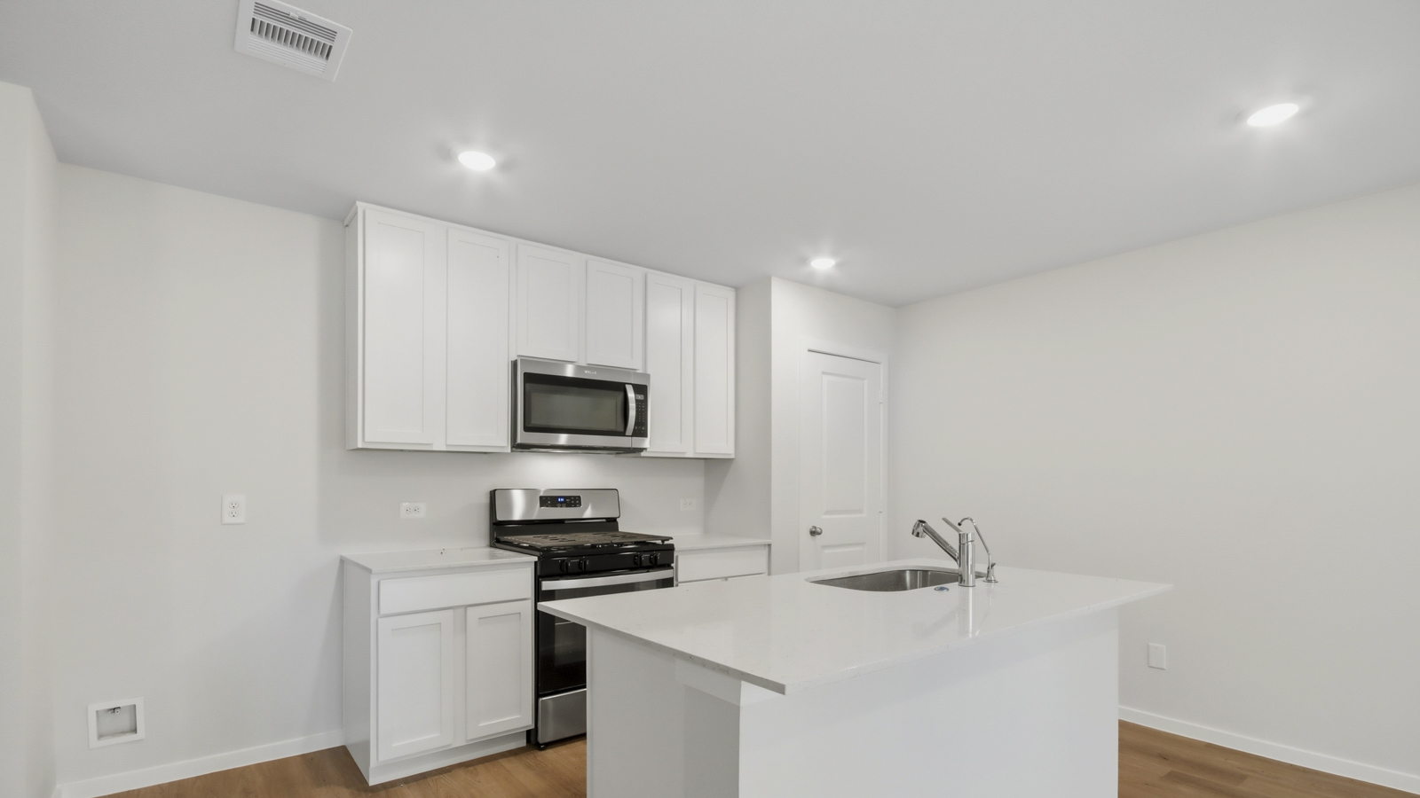 Kitchen with stainless steel appliances, quartz countertops and modern hardware and an island and vinyl floor
