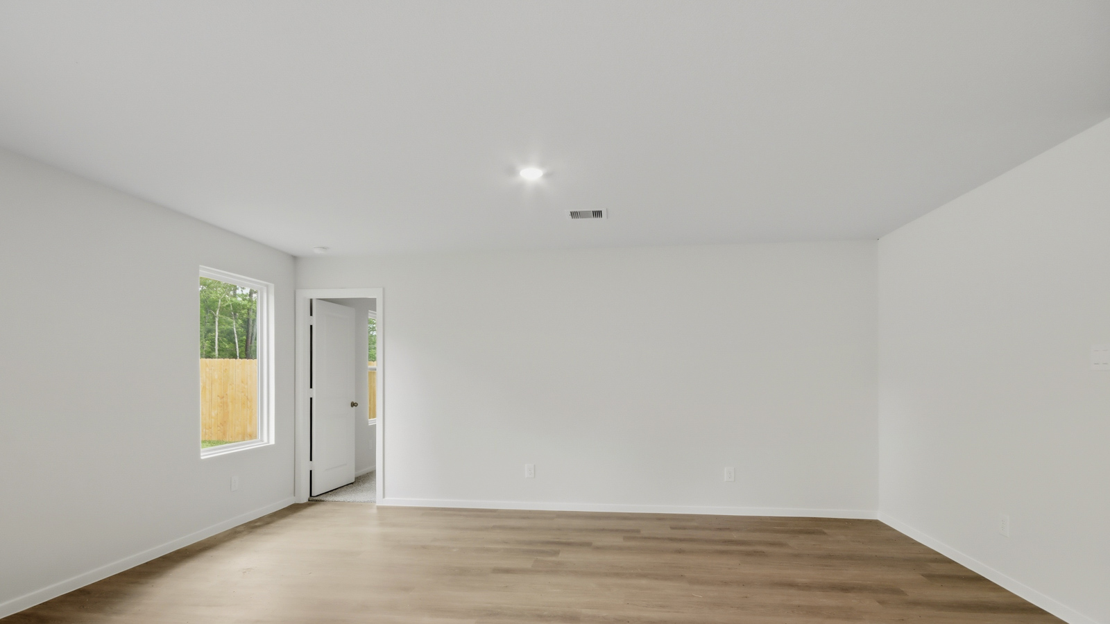 Spacious living area with vinyl flooring and bright windows in New Waverly TX