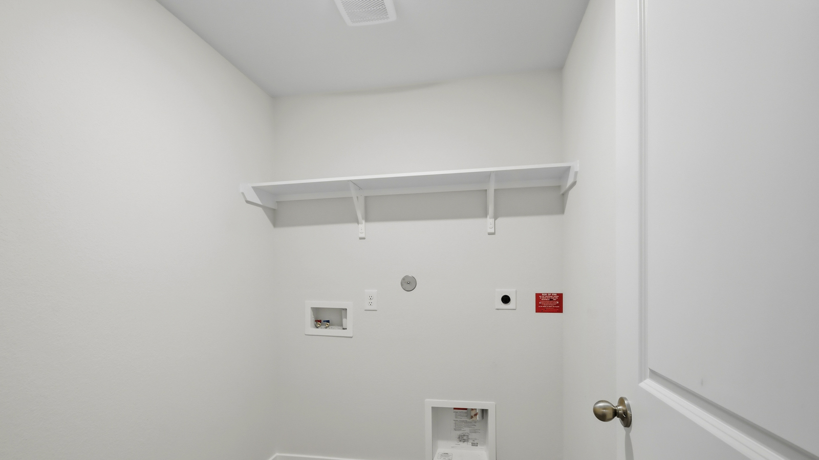 Utility room with storage located off the entry hallway and garage door