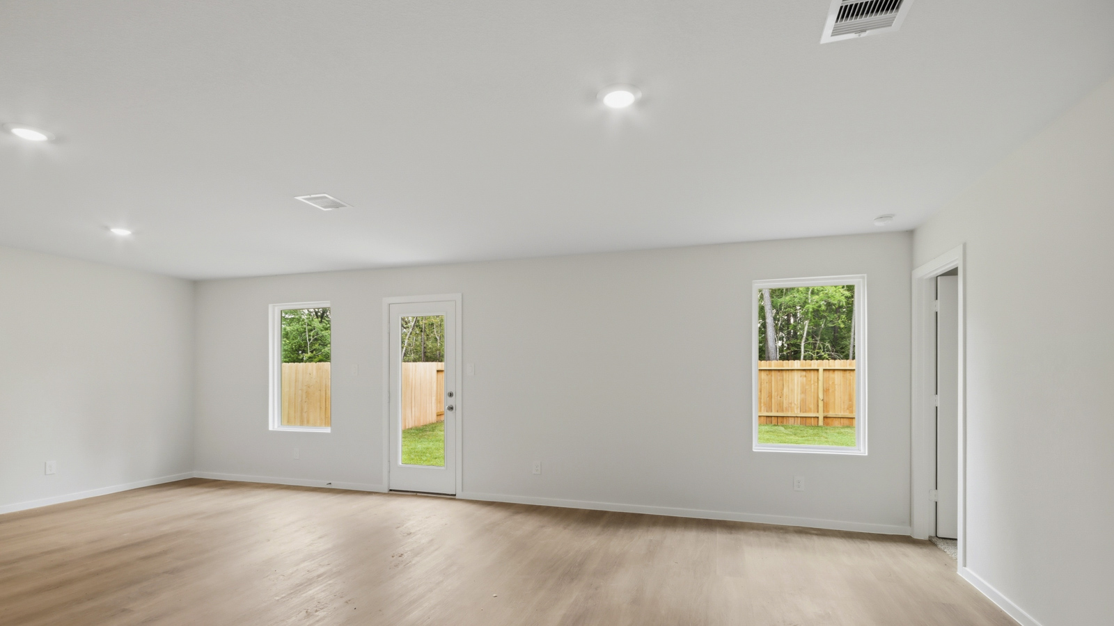 Spacious living area with vinyl flooring and bright windows in New Waverly TX