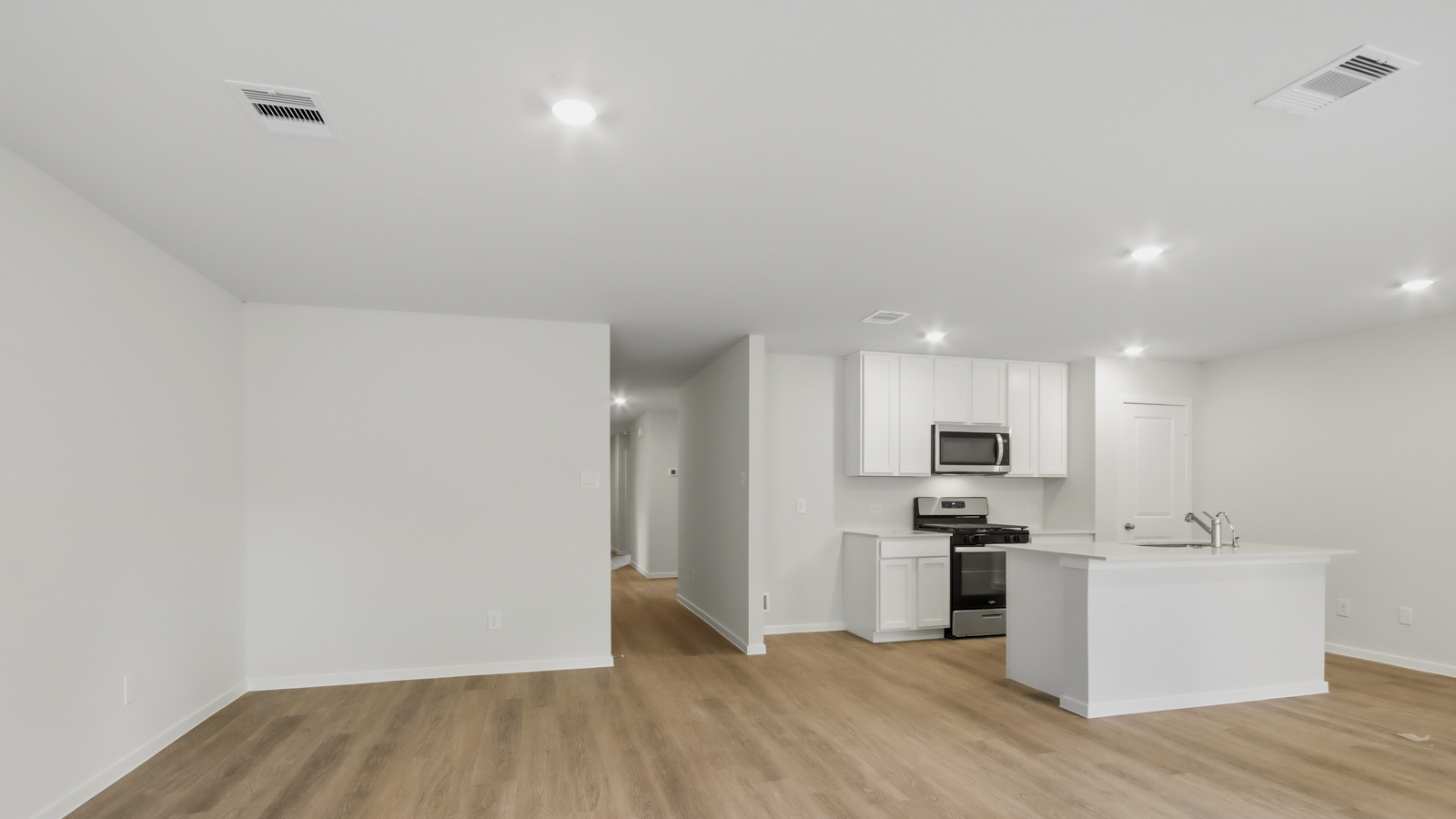 Kitchen with stainless steel appliances, quartz countertops and modern hardware and an island and vinyl floor
