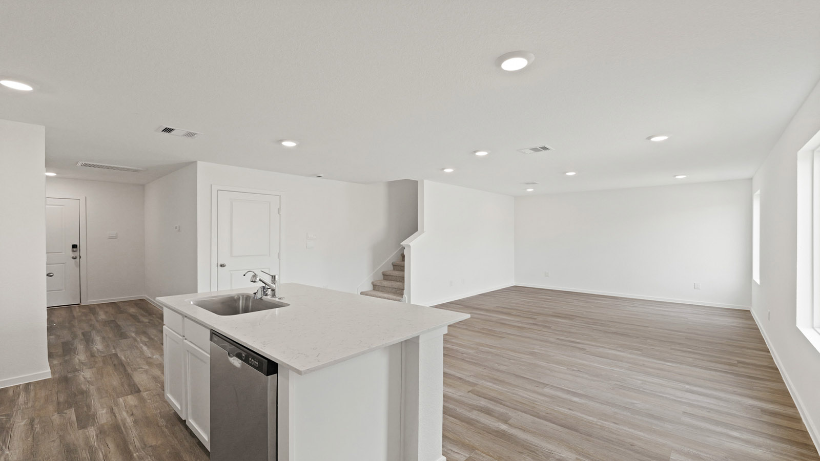 Kitchen with quartz countertops and modern hardware and an island and vinyl floor