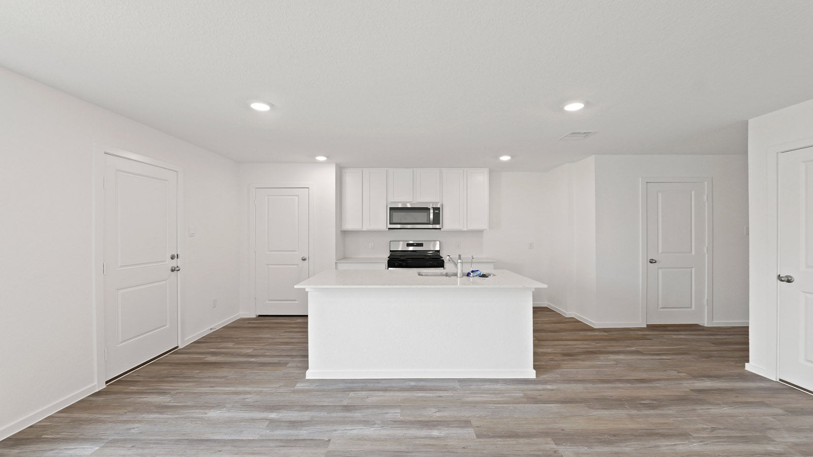 Kitchen with quartz countertops and modern hardware and an island and vinyl floor