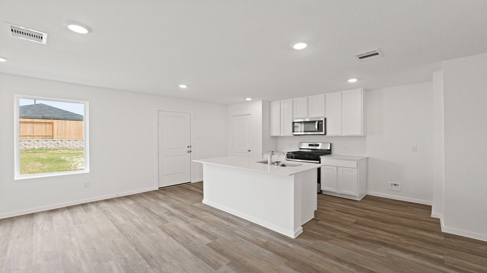 Kitchen with quartz countertops and modern hardware and an island and vinyl floor