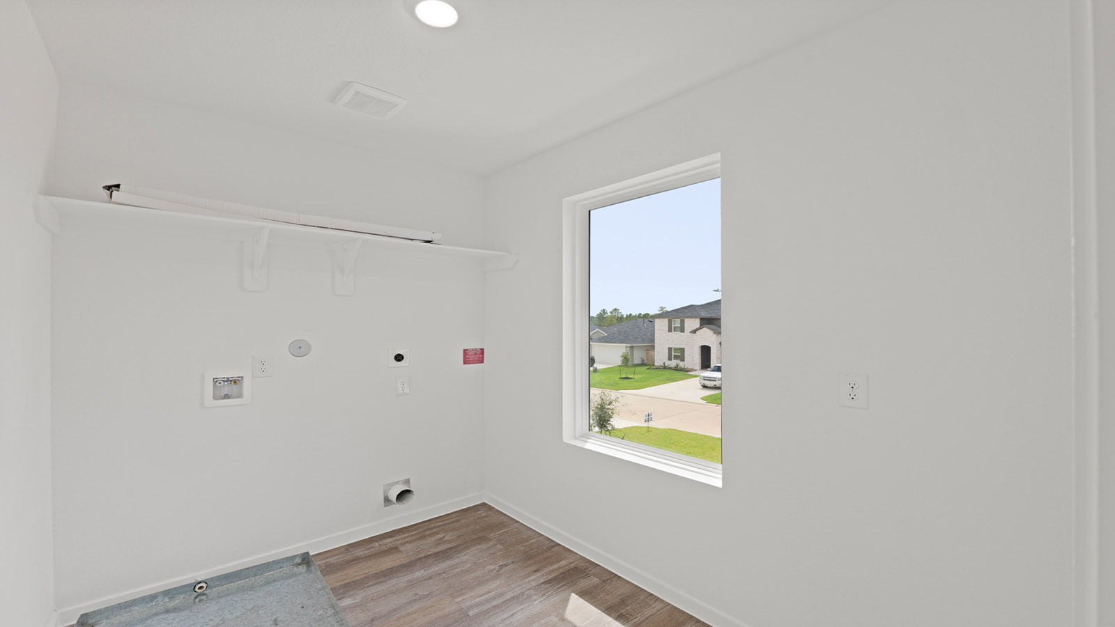 Utility room with storage located off the entry hallway and garage door