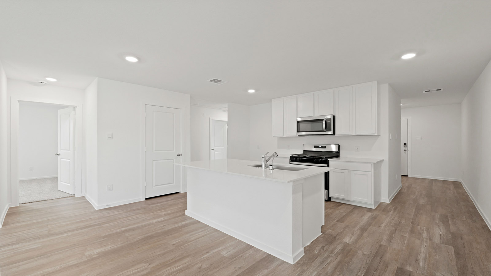Kitchen with quartz countertops and modern hardware and an island and vinyl floor