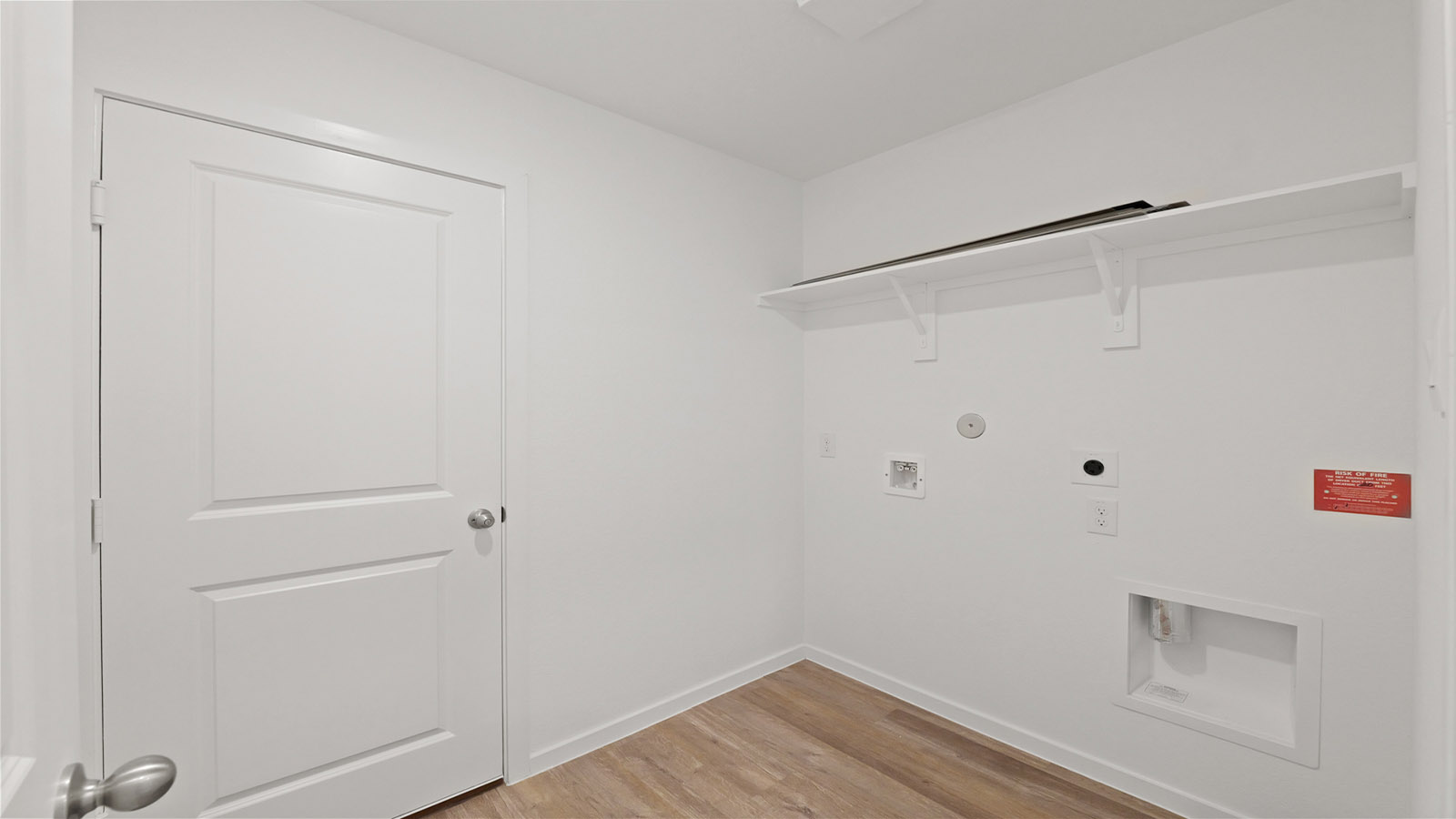 Utility room with storage located off the entry hallway and garage door