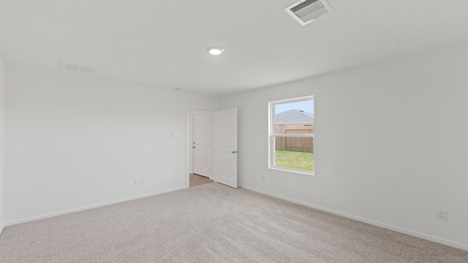 Large Primary bedroom with shag carpet flooring and bright window