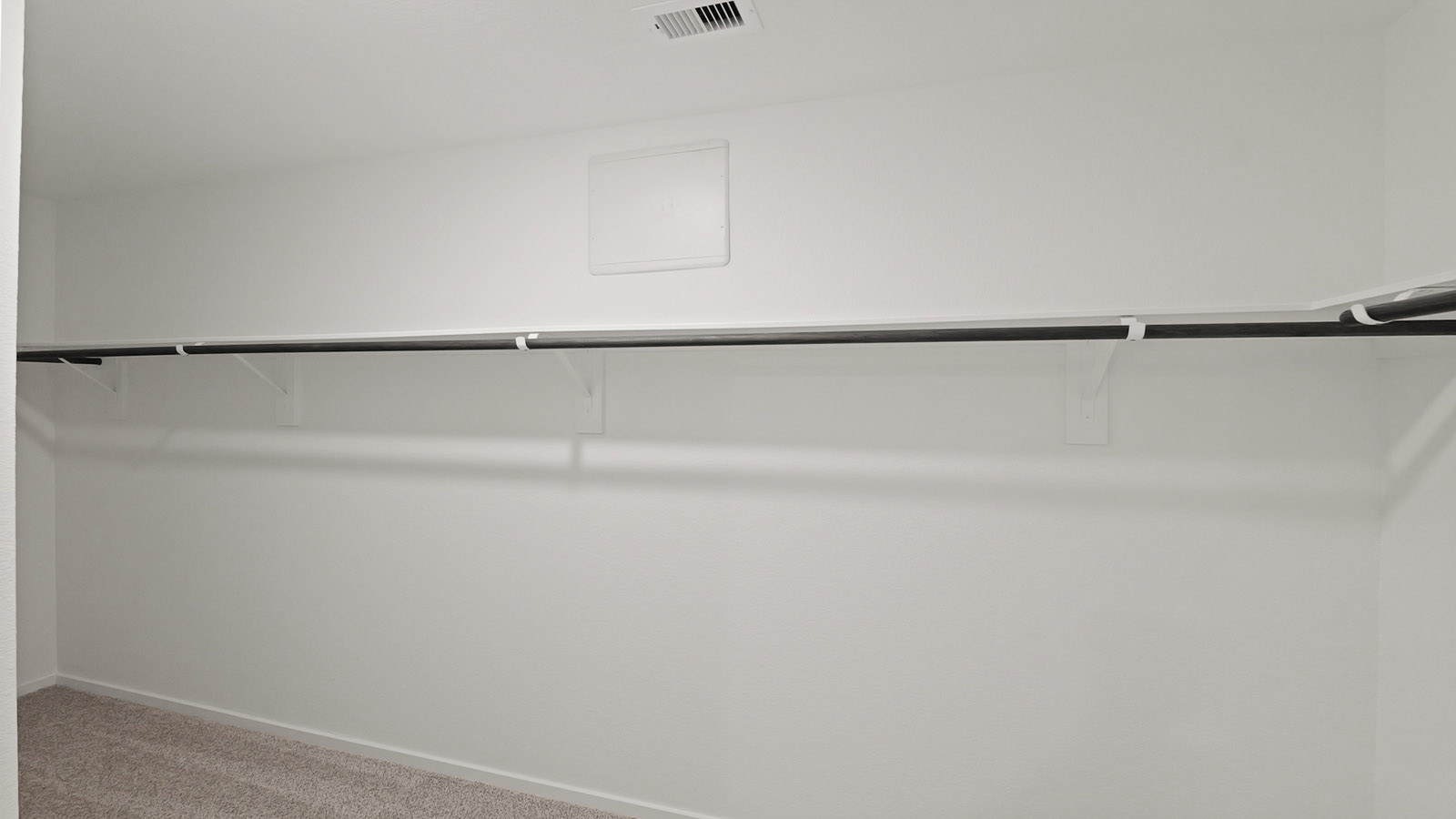 Primary bedroom walk-in closet with carpet flooring in Lake Conroe Cove community in Willis TX