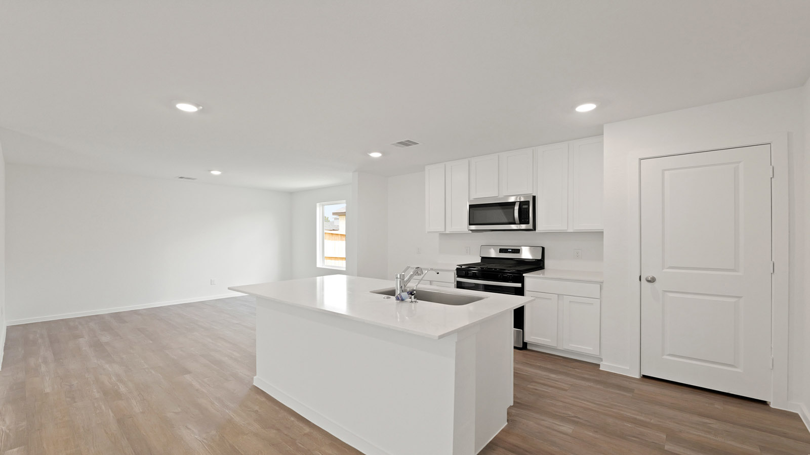 Kitchen with quartz countertops and modern hardware and an island and vinyl floor