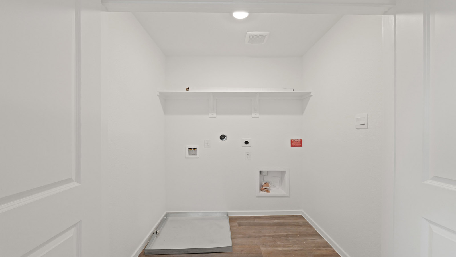 Utility room with storage located off the entry hallway and garage door
