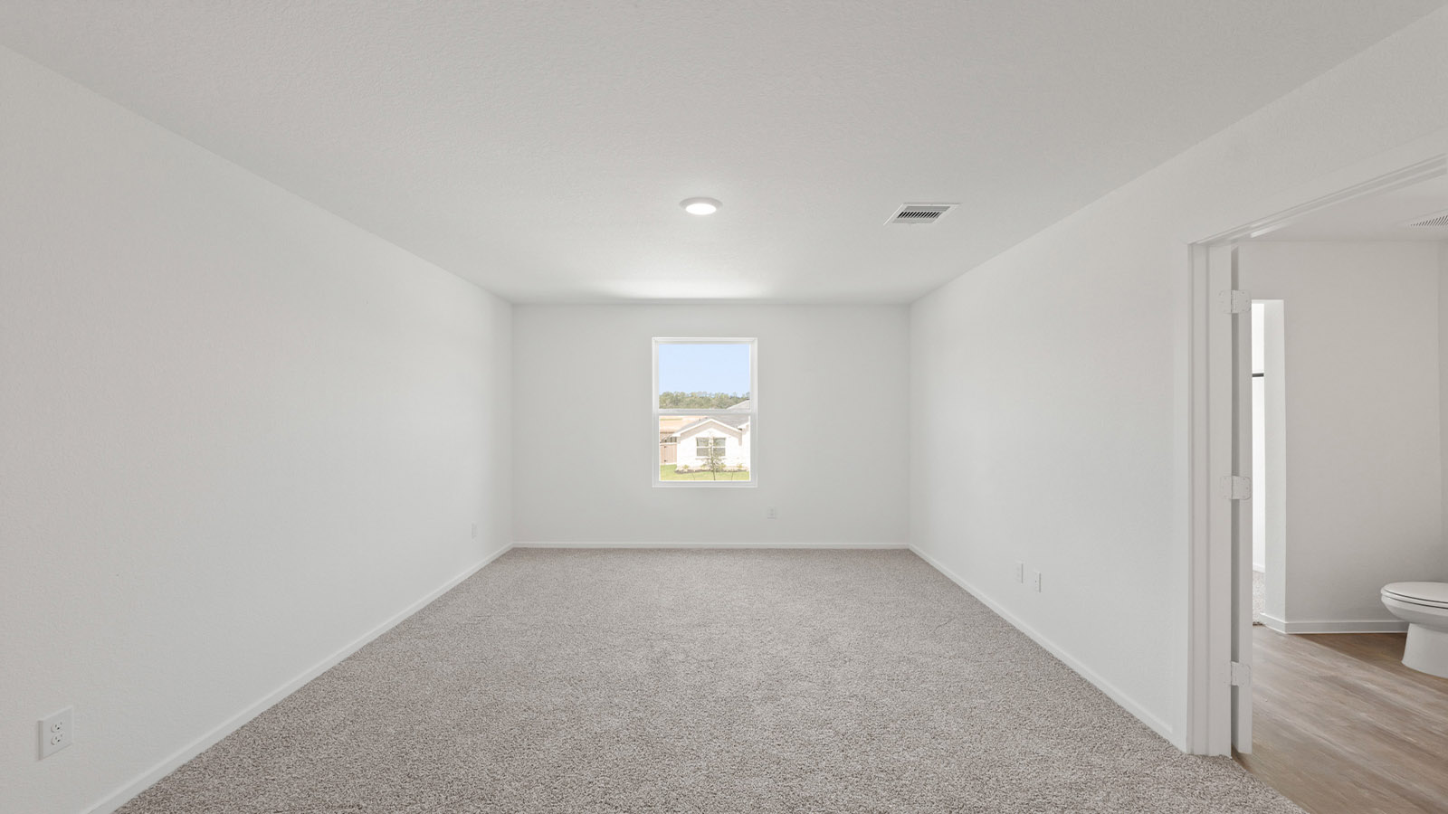Large Primary bedroom with shag carpet flooring and bright window