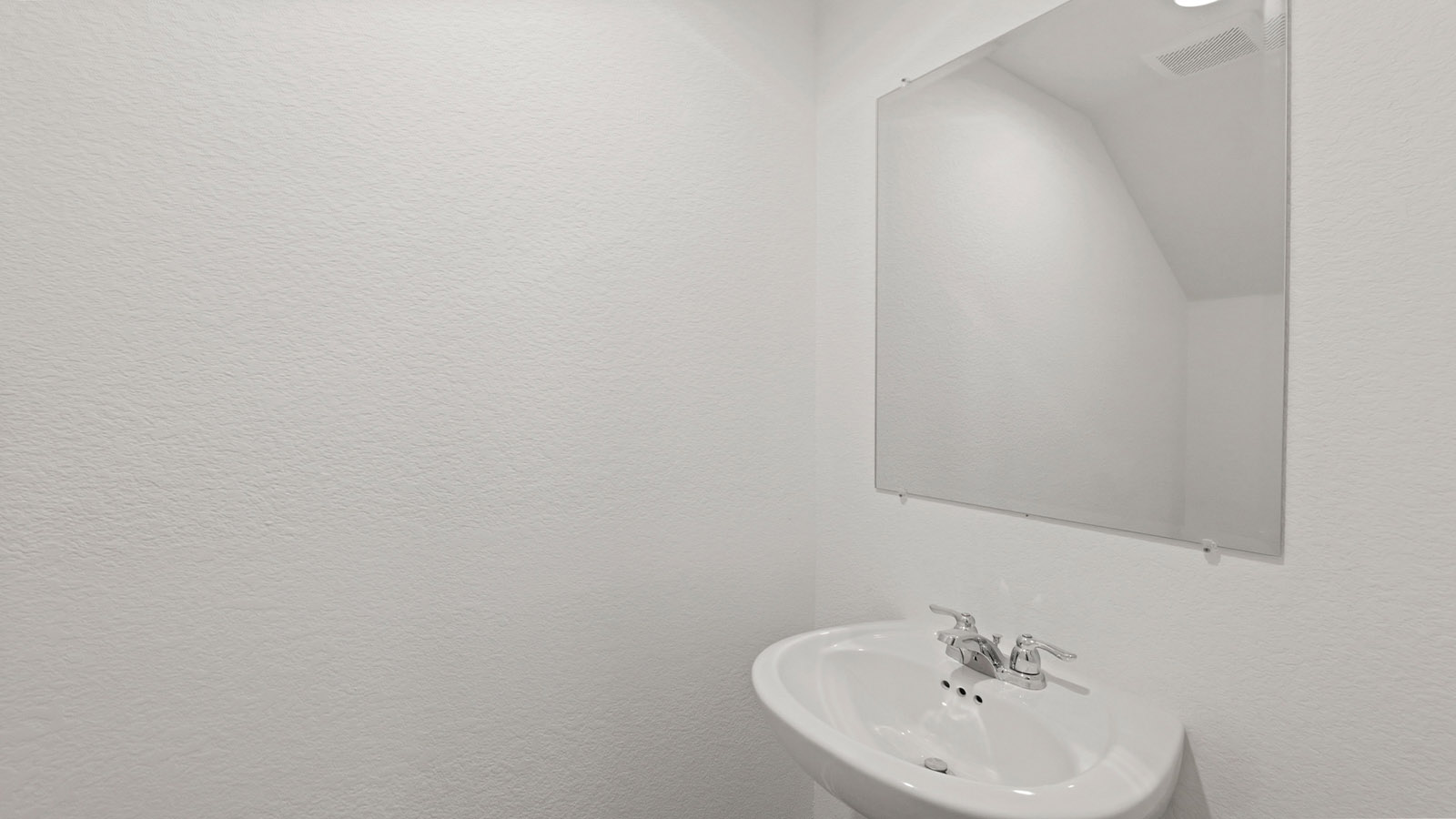 Powder bathroom with pedestal sink right off the foyer entry hallway