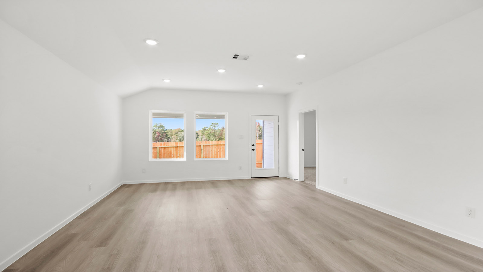 Spacious living area with vinyl flooring