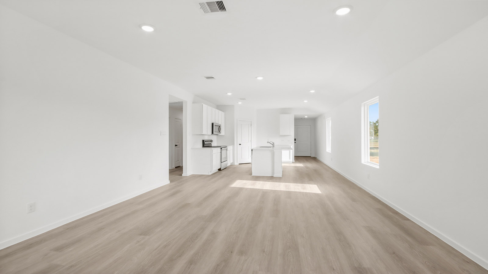Spacious living area with vinyl flooring