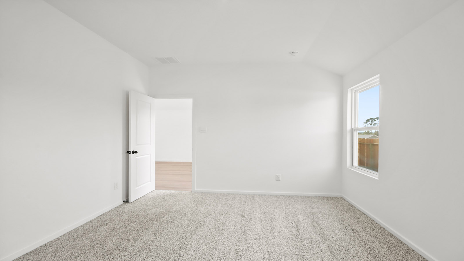 Large Primary bedroom with shag carpet flooring and bright window