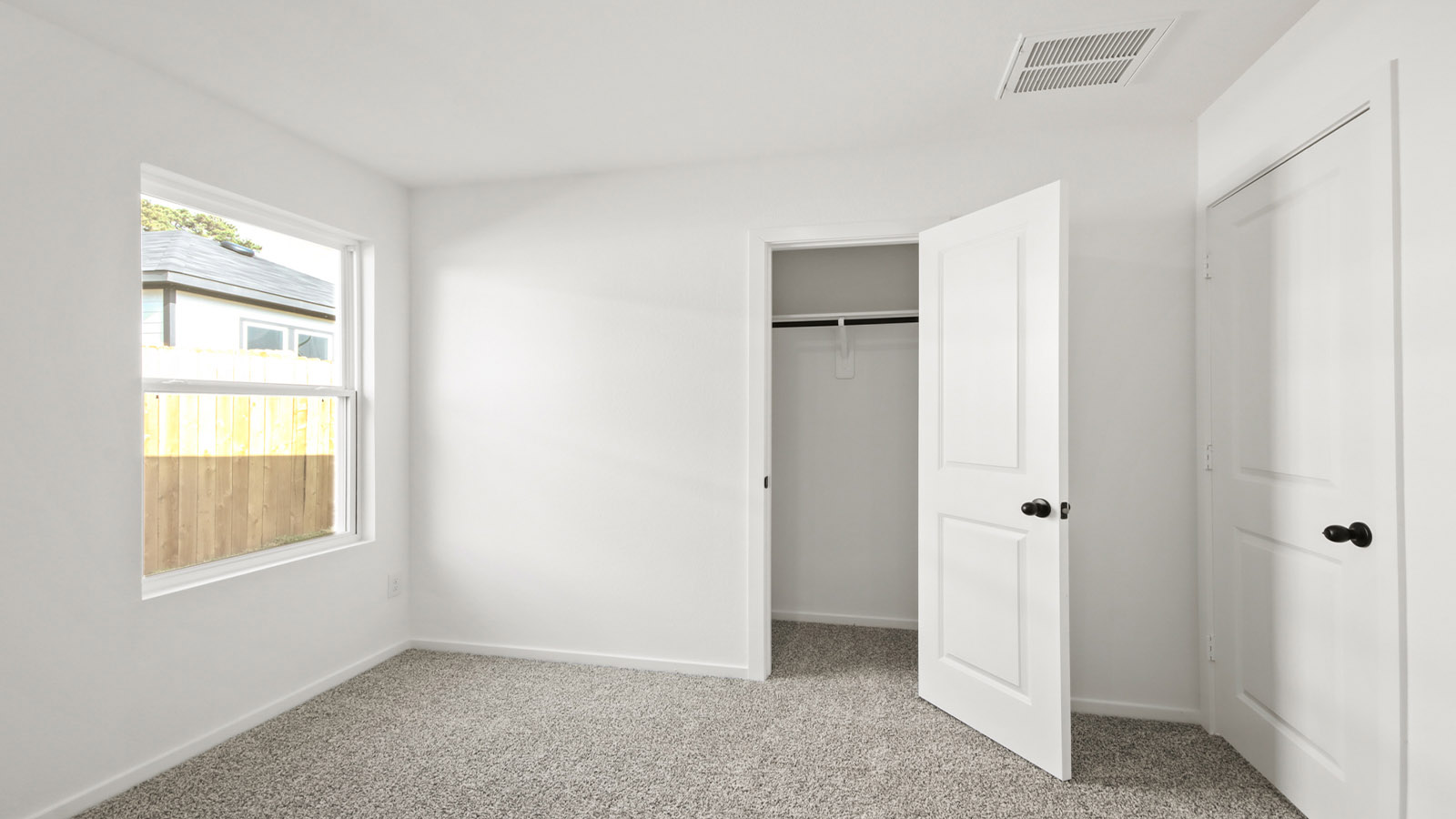 Secondary bedroom with shag carpet flooring and bright window
