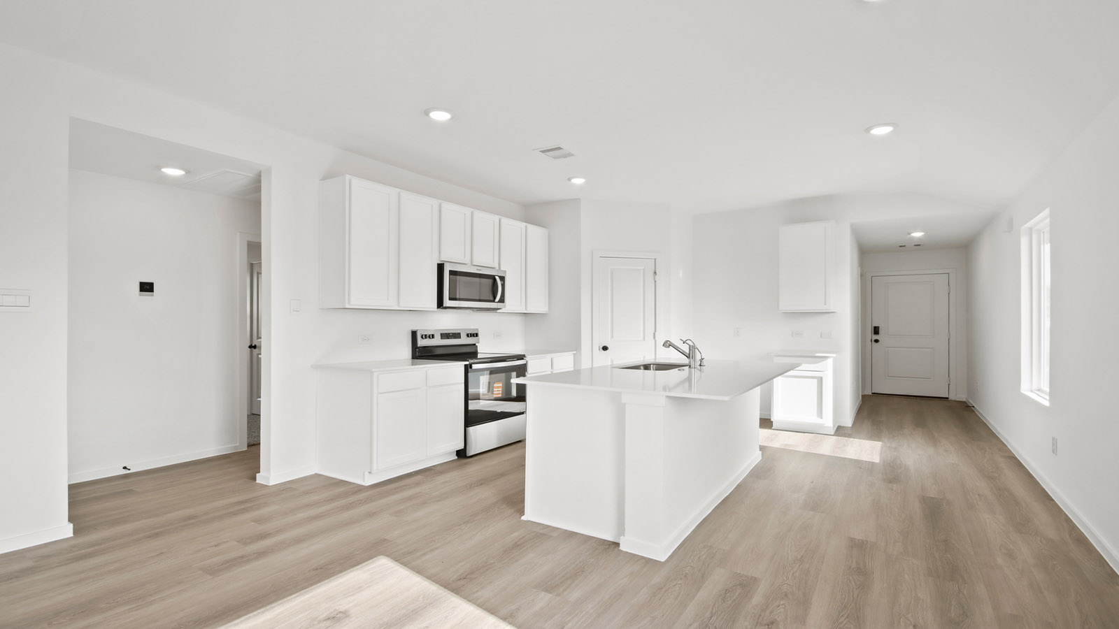 Kitchen with quartz countertops and modern hardware and an island and vinyl floor