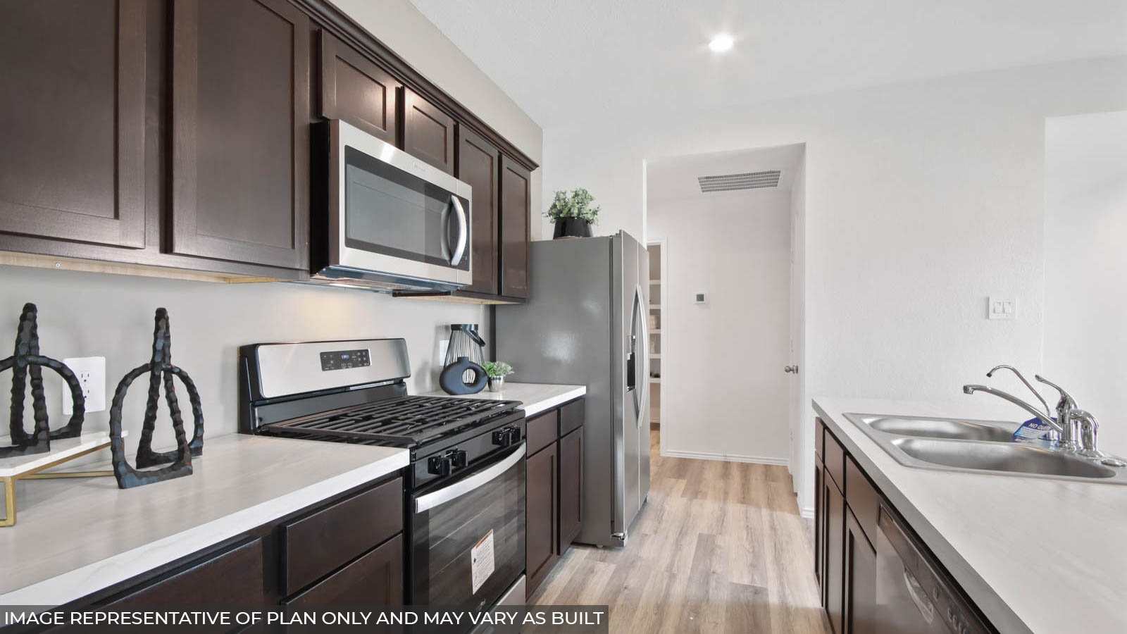 Open kitchen with an island, stainless steel appliances, white cabients, white walls, and vinyl wood flooring.