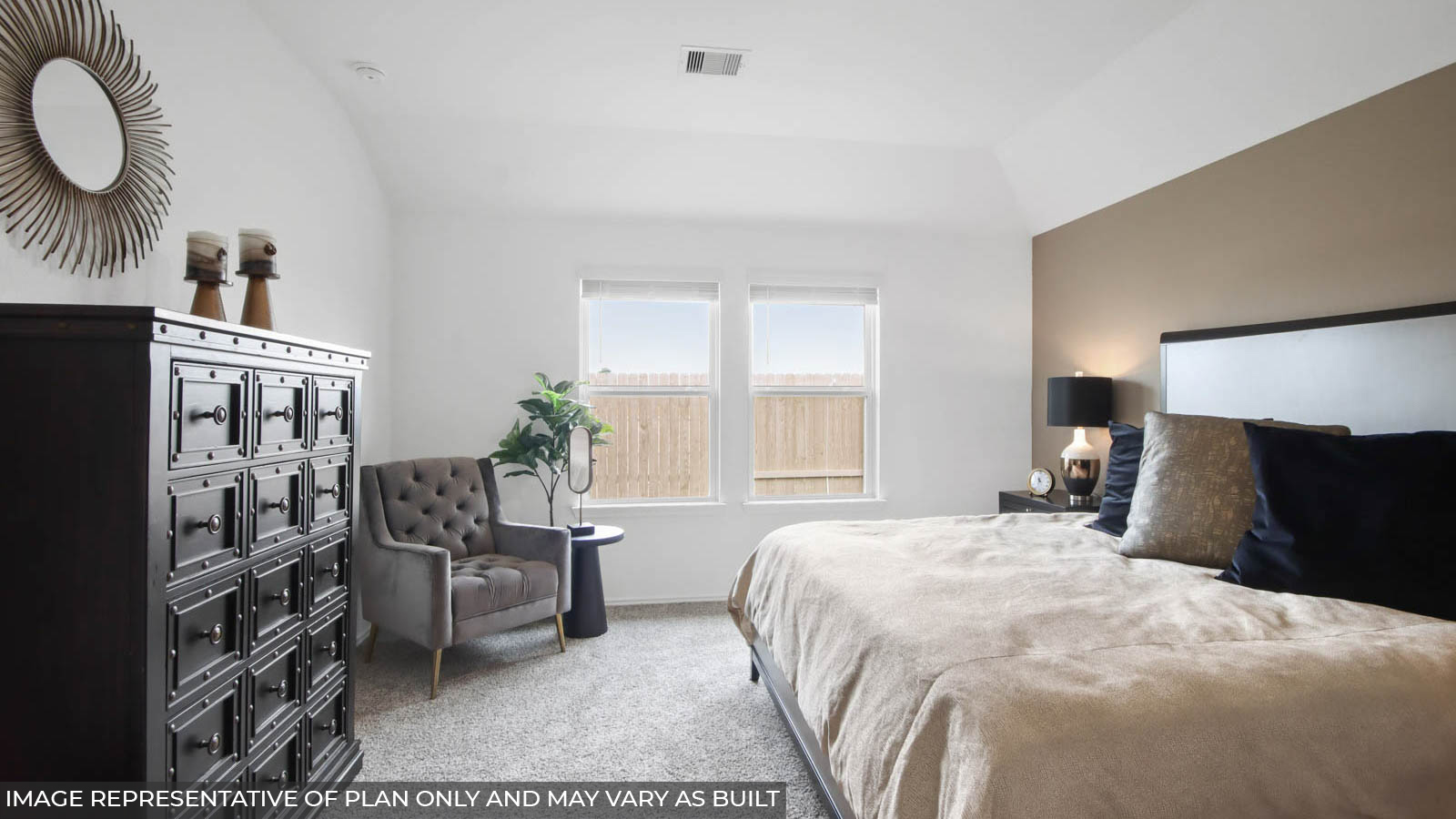 Primary bedroom with windows, white walls, and light carpet.