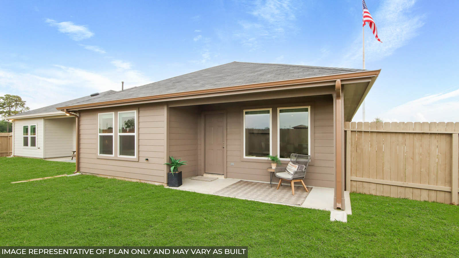 Landscpaed backayrd with a covered patio.