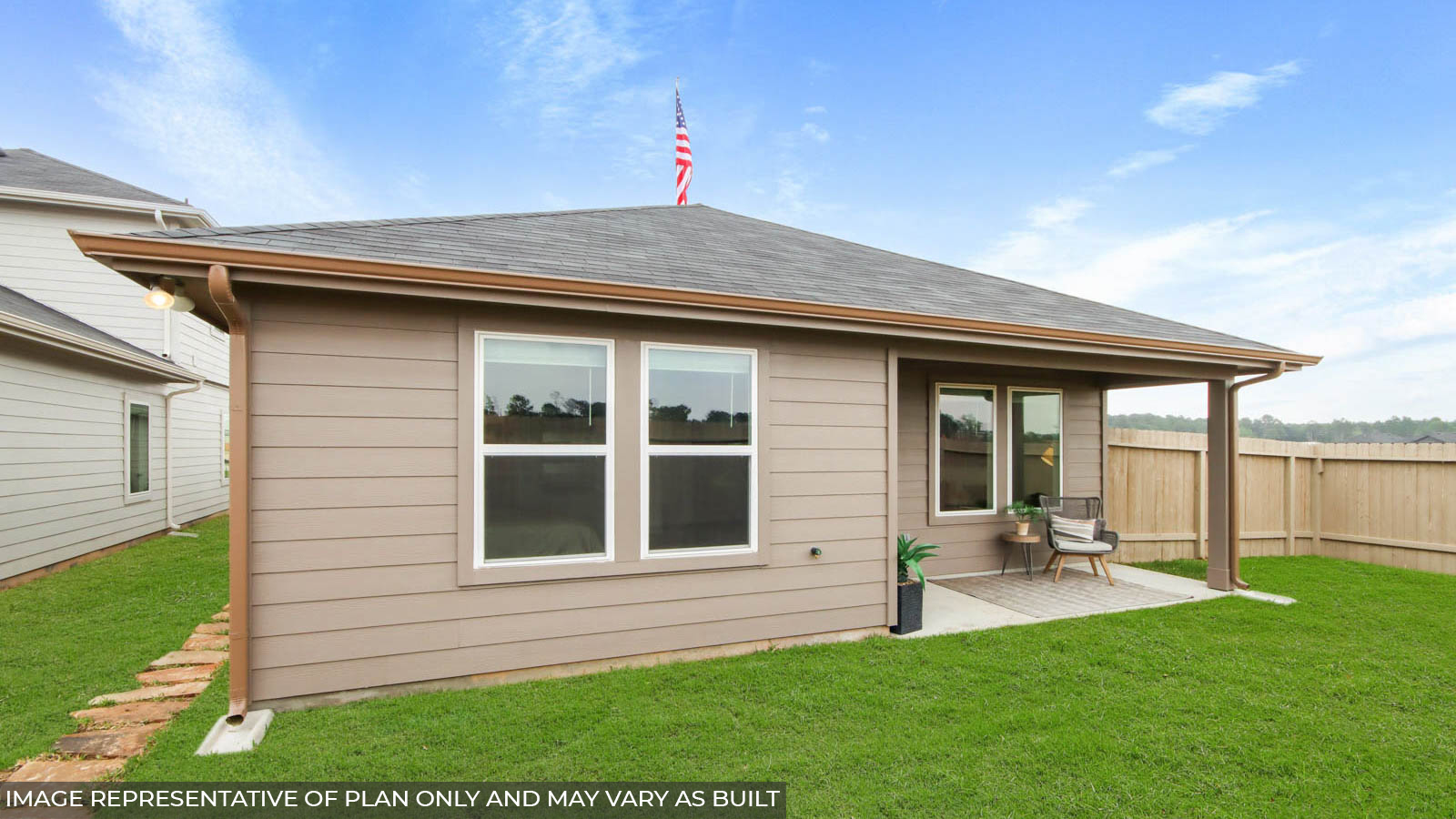 Landscpaed backayrd with a covered patio.