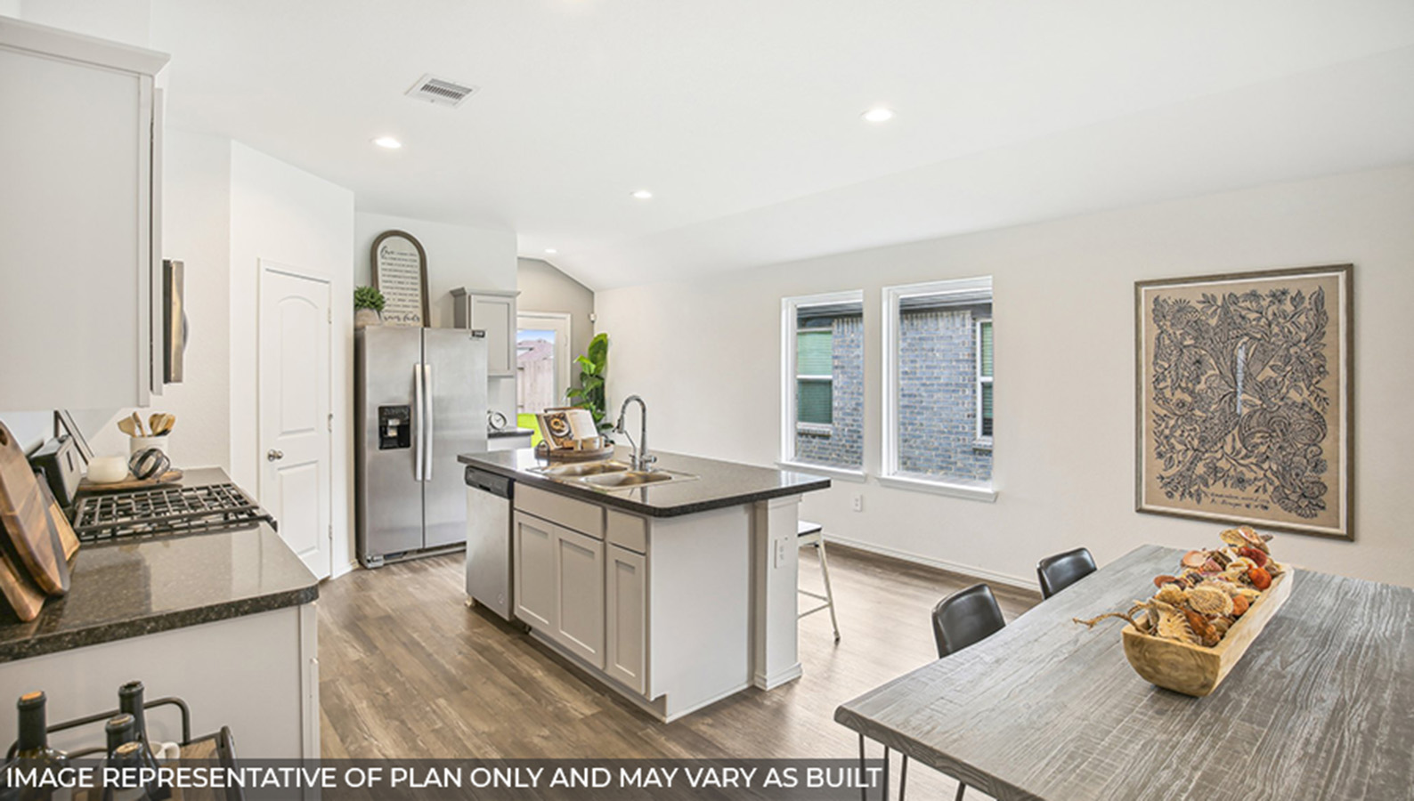 Open kitchen with an island, stainless steel appliances, white cabinets, white walls, and vinyl wood flooring.