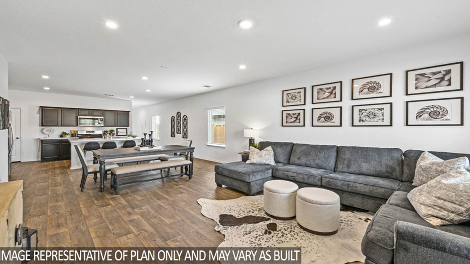 Open living room with windows, white walls, and vinyl wood flooring.