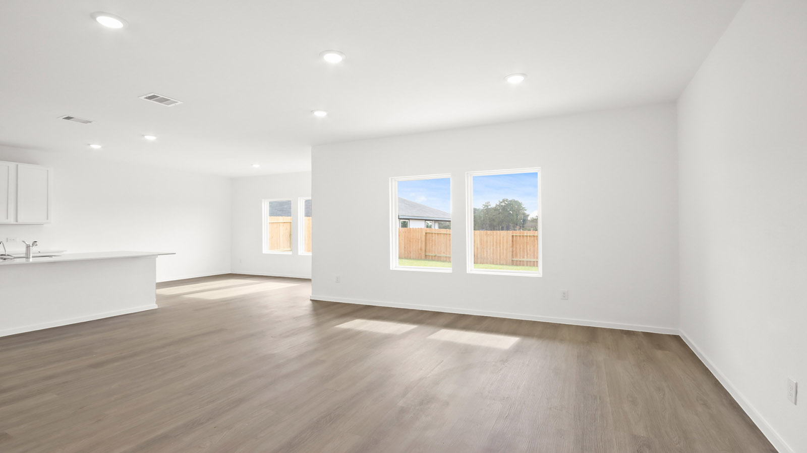 Spacious living area with vinyl flooring