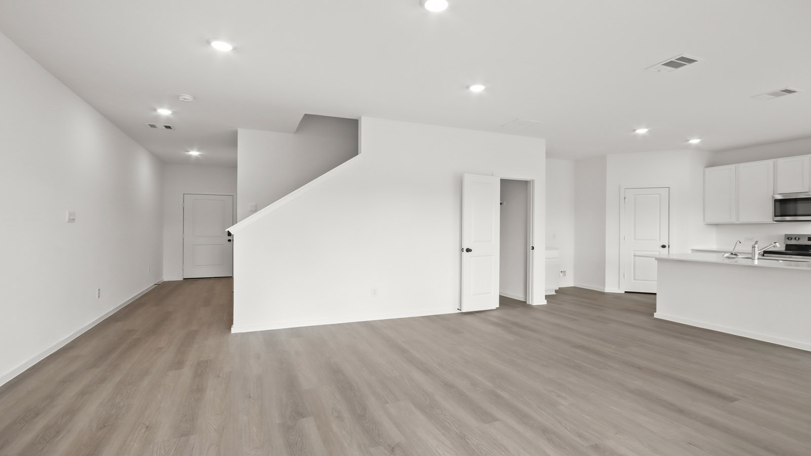 Spacious living area with vinyl flooring