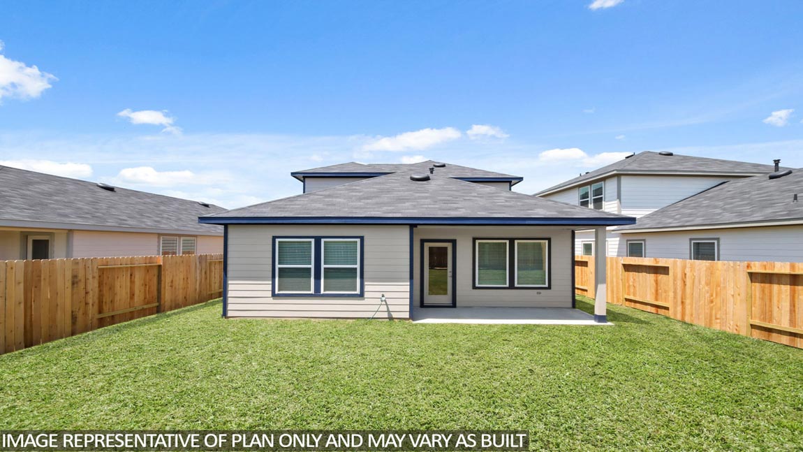 Landscpaed backyard with a covered patio.