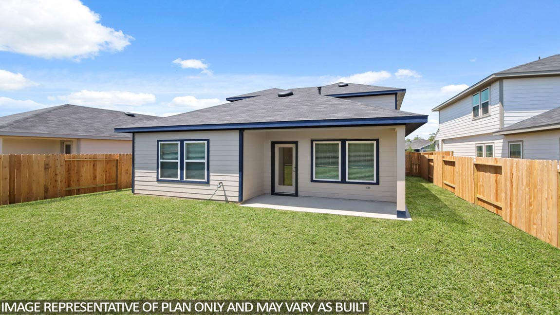 Landscpaed backyard with a covered patio.