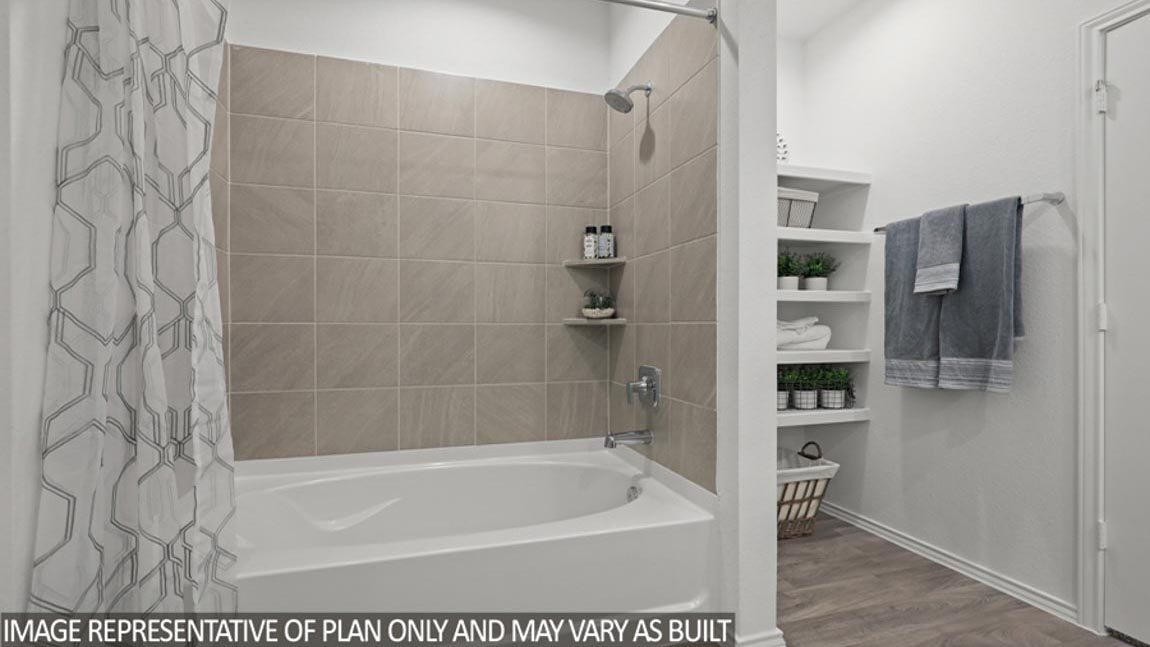 Primary bathroom with dual sinks, walk-in shower, storage shelves, white walls, and vinyl wood flooring.