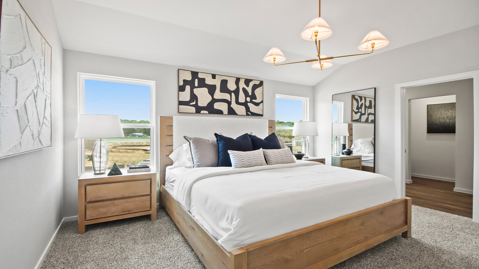 primary bedroom with large windows and carpet flooring